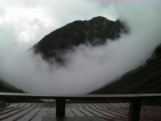 雨の涸沢ヒュッテのテラスから、ガス(雲)から突如現れた山