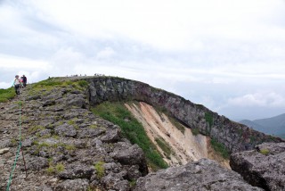【反対側の端からの景色】山頂がなだらかなのがわかる、このあたりの崖ギワに大きくヒビがあるのも見える。